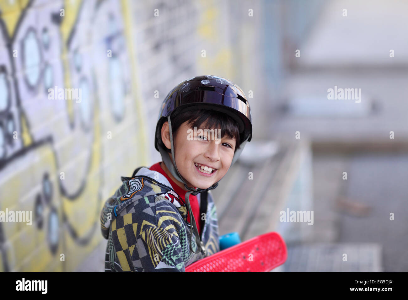 Kleiner Junge im Skateboard-Helm Stockfoto