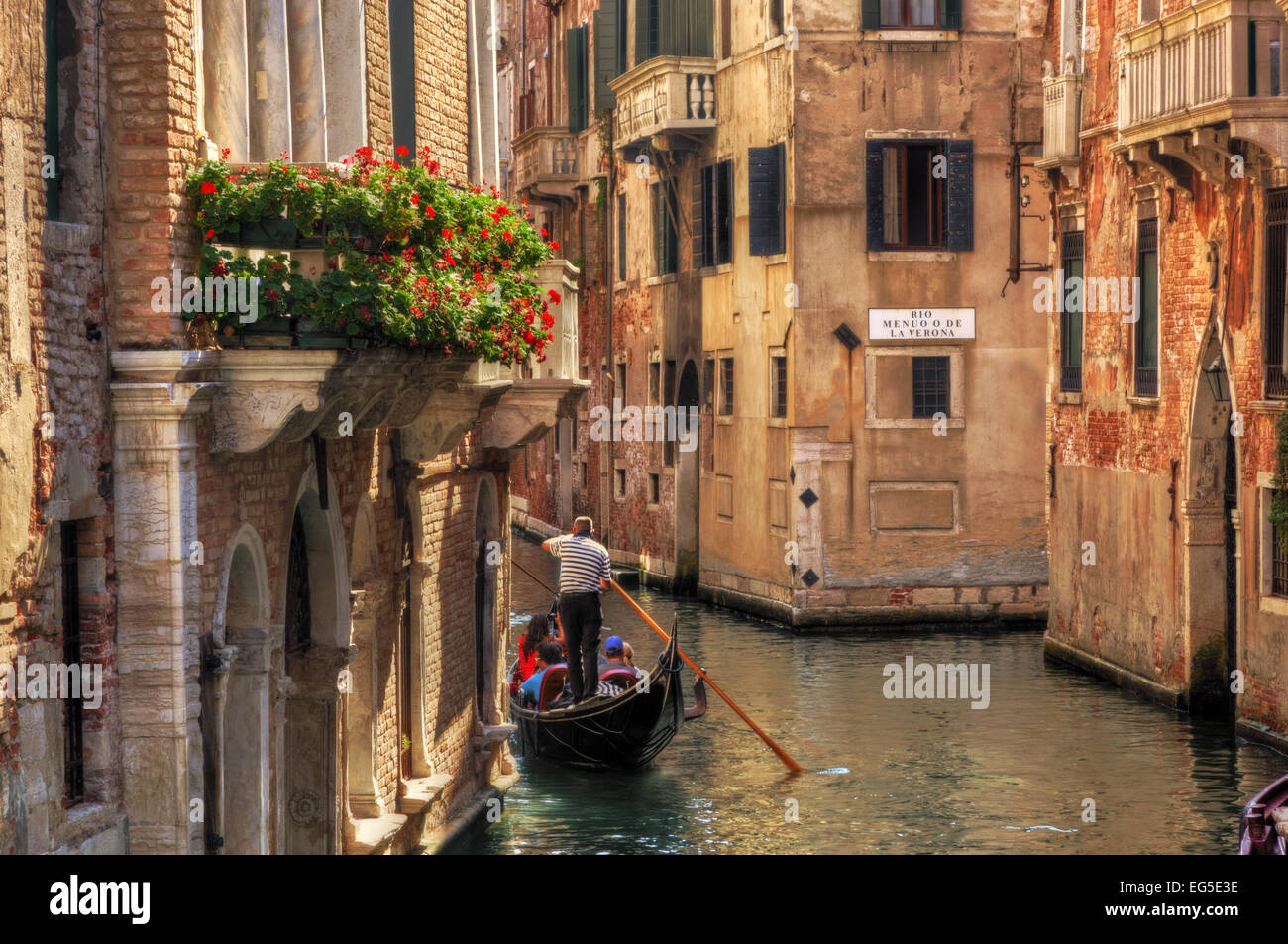 Venedig, Italien. Eine romantische Gondelfahrt schwimmt auf einem schmalen Kanal unter alten venezianischen Architektur Stockfoto