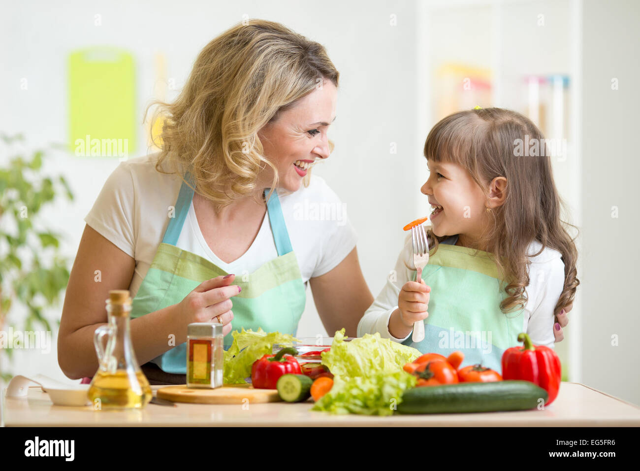 Mutter und ihr Kind gesundes Essen zubereiten und dabei Spaß haben Stockfoto