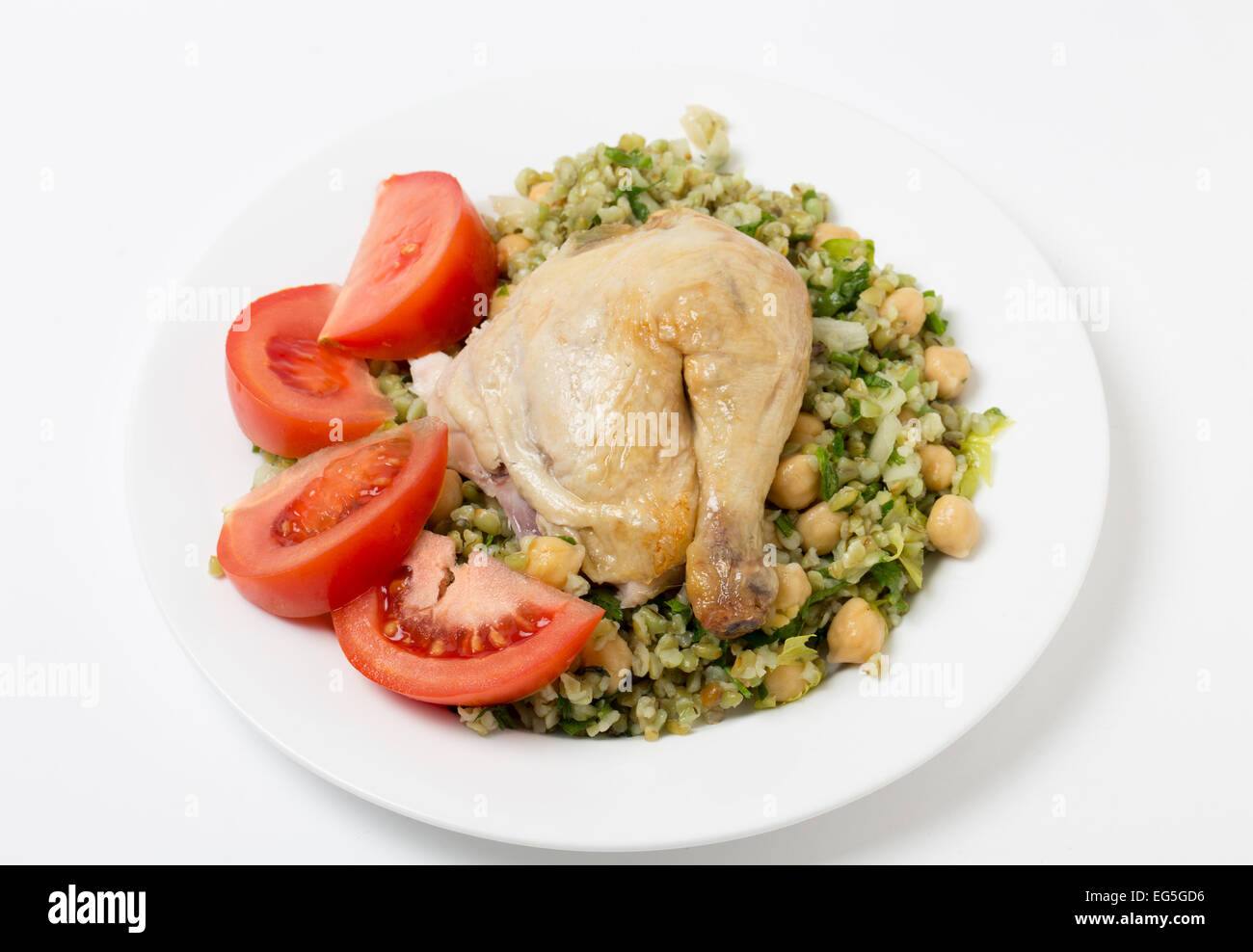 Freekeh Salat mit Kichererbsen, Zwiebel, Petersilie, Sellerie, Zitronensaft und Olivenöl Dressing und ein Hühnerbein mit Tomate Stockfoto