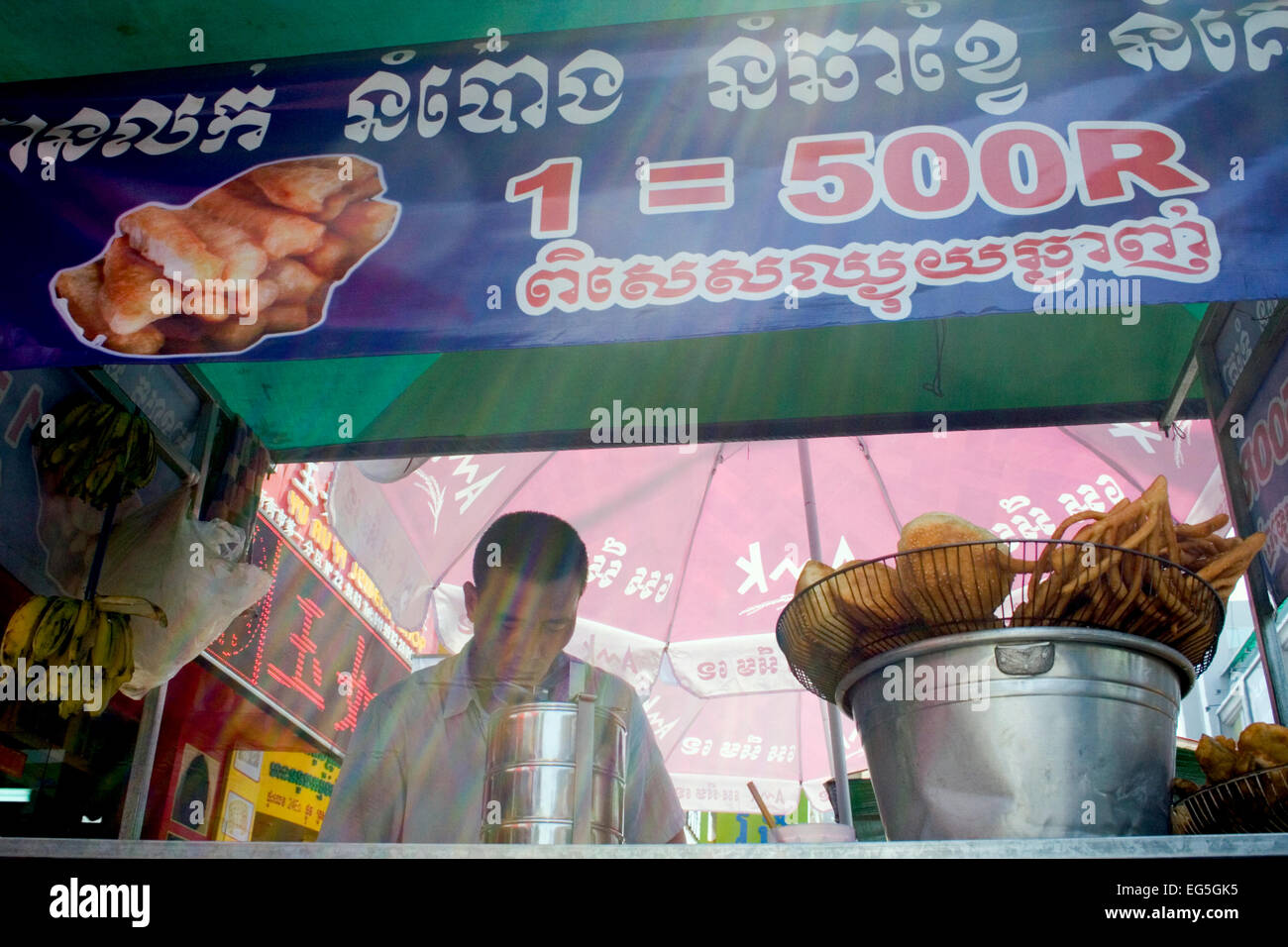 Ein Mann ist verschiedenen Brot in heißem Öl kochen und servieren es als Straße Nahrung auf eine Stadt Straße in Phnom Penh, Kambodscha. Stockfoto