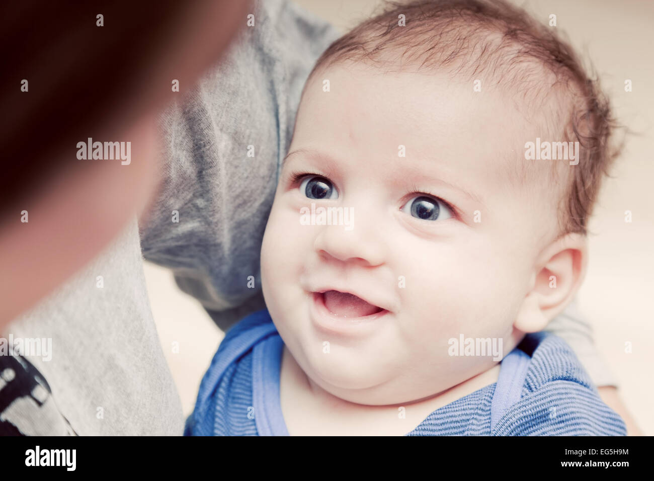 3 Monate baby seines Elternhauses Augen betrachten und versuchen zu Lächeln Stockfoto