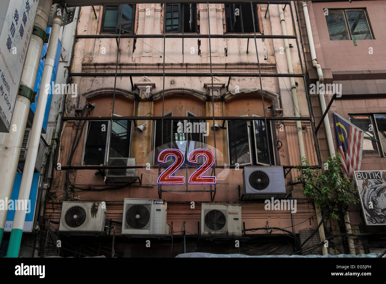 Neon Schild Nummer 22 und Klimaanlagen auf Fassade eines alten Gebäudes in Chinatown, Kuala Lumpur, Malaysia. Stockfoto