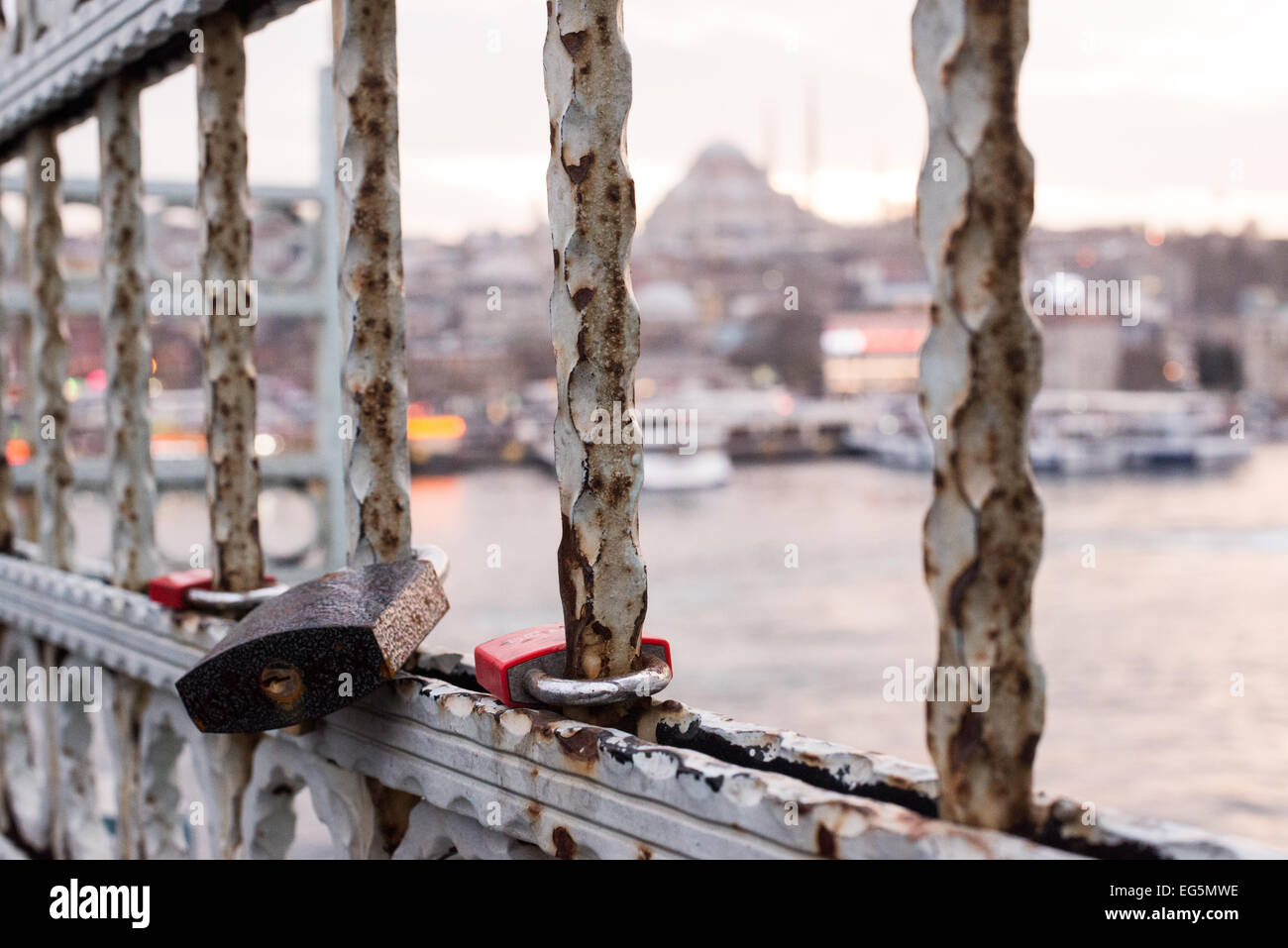 ISTANBUL, Türkei – Love Loses zieren das Geländer der zweistöckigen Galata-Brücke, die das Goldene Horn überspannt, mit der historischen Suleymaniye-Moschee im Hintergrund. Die Brücke, die Eminonu mit Karakoy verbindet, beherbergt sowohl Fahrzeuge als auch Straßenbahnen auf der oberen Ebene, während sich darunter Restaurants befinden. Diese moderne Tradition, Vorhängeschlösser als Symbole der Liebe anzubringen, hat sich auf Brücken weltweit ausgebreitet. Stockfoto