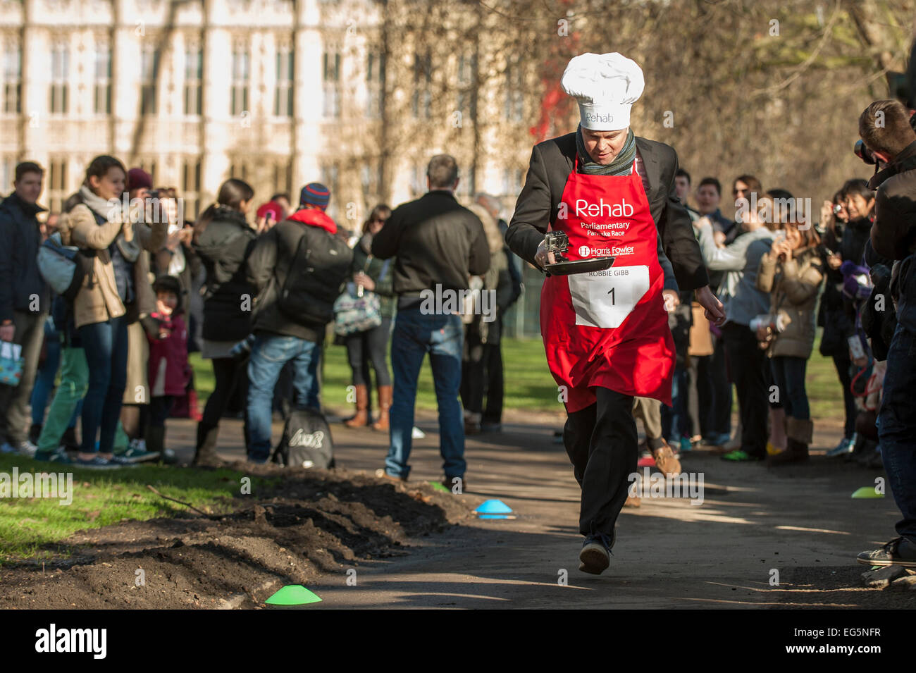 London, UK. 17. Februar 2015.   M/s, Lords und Mitglieder der parlamentarischen Pressetribüne nehmen Teil in der jährlichen, Nächstenliebe parlamentarischen Pancake Race in Victoria Tower Gardens, neben den Houses of Parliament am Faschingsdienstag.  Im Bild: Robbie Gibb, BBC täglich und Sonntag Politik nimmt Teil in das Rennen. Bildnachweis: Stephen Chung/Alamy Live-Nachrichten Stockfoto