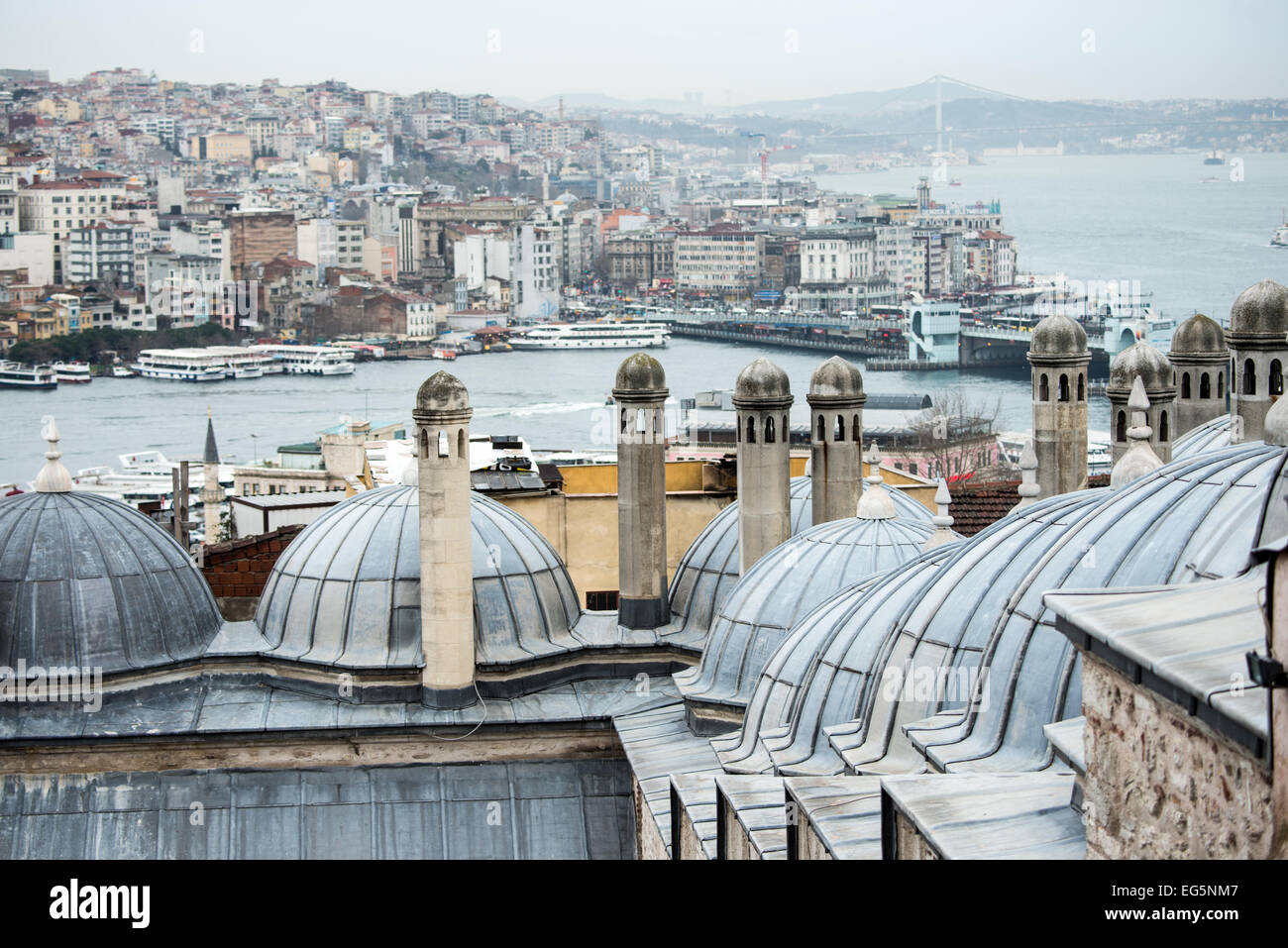 Süleymaniye-Moschee Kuppeln Istanbul Türkei // ISTANBUL, Türkei – Kuppeln mit Kuppeln neben der Suleymaniye-Moschee mit Blick auf die Stadt Istanbul in Richtung Beyoglu. Die architektonischen Details zeigen klassische osmanische Designelemente aus dem 16. Jahrhundert. Diese sekundären Kuppeln ergänzen die Hauptstruktur der Moschee und bieten einen Panoramablick über die historische Halbinsel Istanbuls. Stockfoto