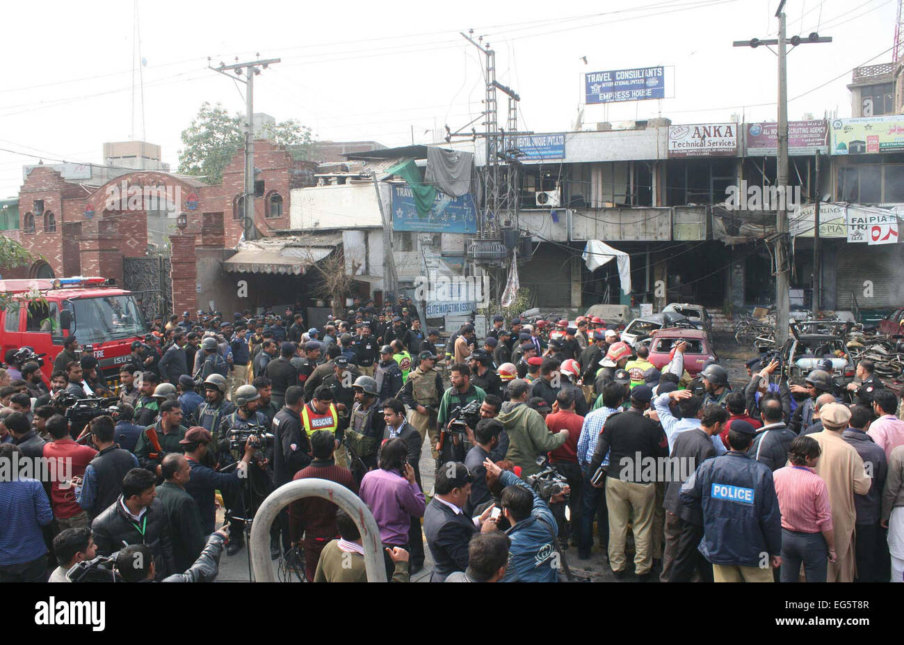 Menschen sammeln am Veranstaltungsort nach suizidalen Bombardierung in der Nähe von Polizeilinien in Qila Gujar Singh Bereich von Lahore auf Dienstag, 17. Februar 2015. Acht Menschen wurden in einer Explosion getötet. Mehrere Fahrzeuge nach der Explosion Feuer gefangen und die Straßen waren übersät mit Glas, da brach die Fenster der Gebäude in der Nähe. Eine abtrünnige Fraktion der Tehreek-e-Taliban Pakistan, Jamaatul Ahrar behauptete Verantwortlichkeit für den Angriff. Stockfoto