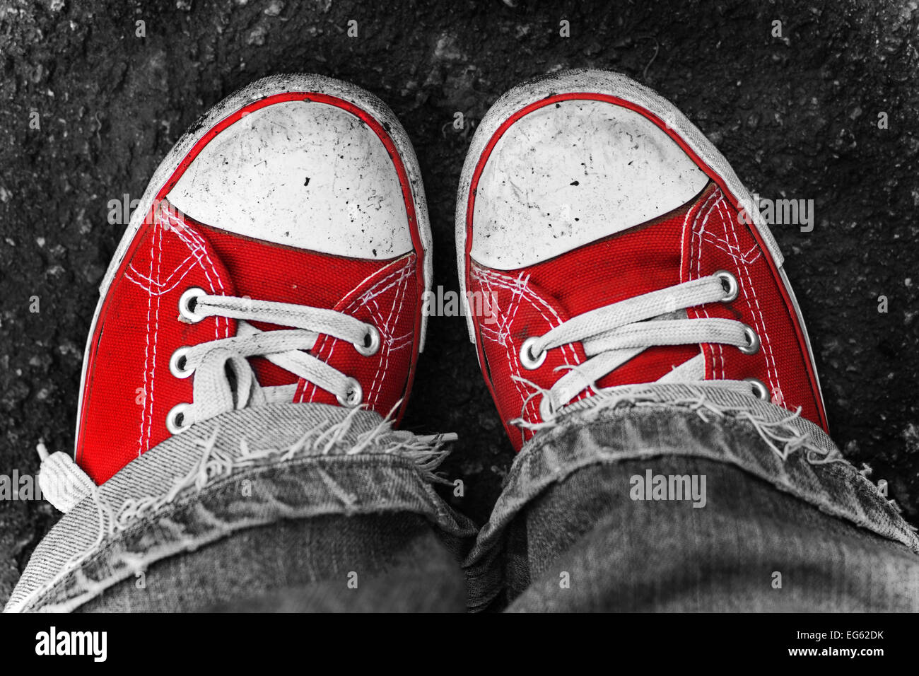 Füße in schmutzige rote Turnschuhe und Jeans im Freien. Ersten Schritt zu machen. Stockfoto