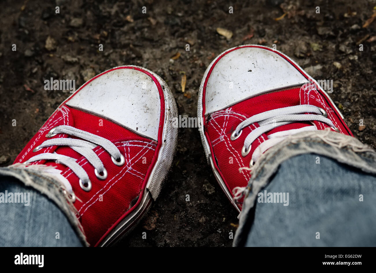 Füße in schmutzige rote Turnschuhe und Jeans im Freien. Ersten Schritt zu machen. Stockfoto