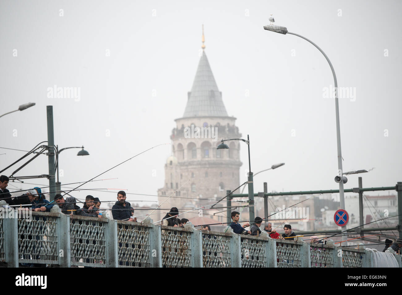 ISTANBUL, Türkei – ISTANBUL, Türkei – Fischer säumen die Galata-Brücke mit dem Galata-Turm im Hintergrund. Eminonu ist eine historische Gegend mit einer reichen osmanischen Vergangenheit und das Herz des alten Istanbul, wo Händler und Touristen sich in einem farbenfrohen Spektakel des kulturellen Austauschs vereinen. Stockfoto