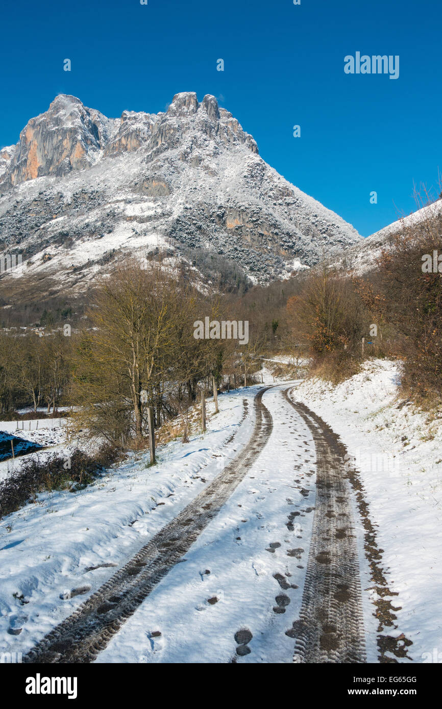 Snowy Track mit Reifenspuren in Richtung schneebedeckten Berg, Sinsat, Ariège, Französischen Pyrenäen, Frankreich Stockfoto