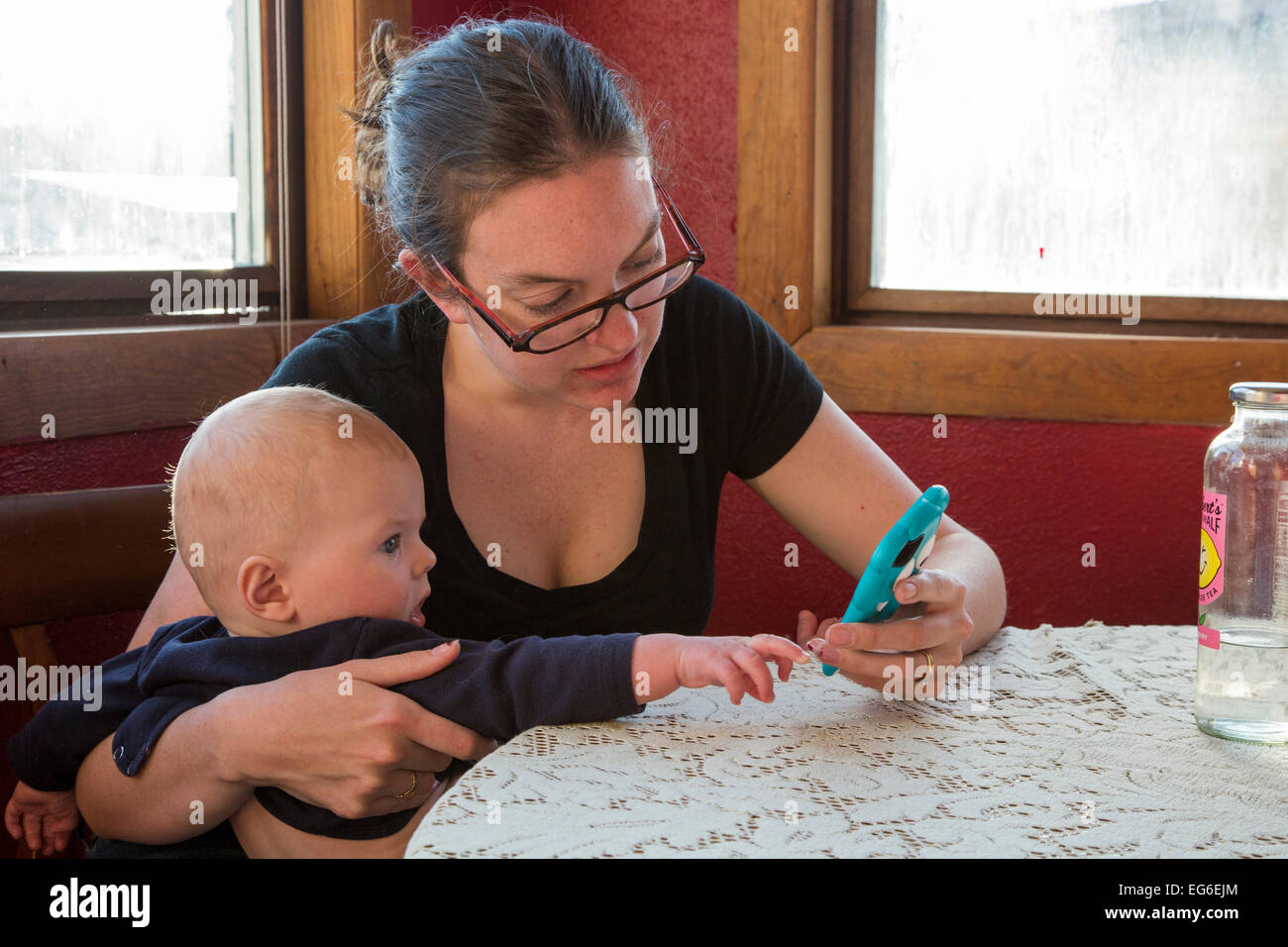 Denver, Colorado - ein sieben Monate altes Baby versucht, seine Mutter mit ihrem Handy zu helfen. Stockfoto