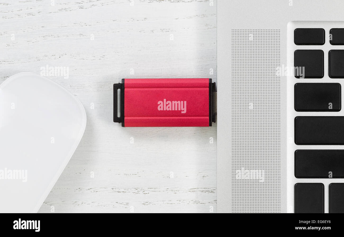 Abgewinkelte Draufsicht Bild von roter Farbe USB-Stick im Laptop USB-Anschluss  und Maus auf weißen Desktop. Sicherheitskonzept Stockfotografie - Alamy