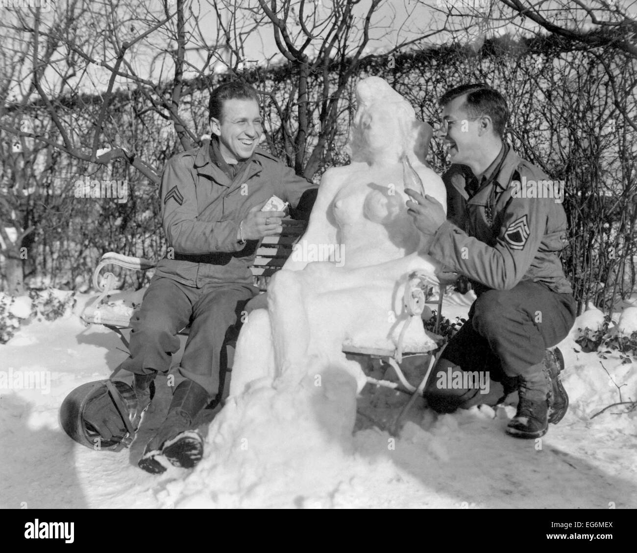 Zwei US-Soldaten bieten "Agnes" ihre Schnee-Frau, Camel Zigaretten und eine Cola. Europäische Theater. 14. Januar 1945. Dem 2. Weltkrieg. Stockfoto