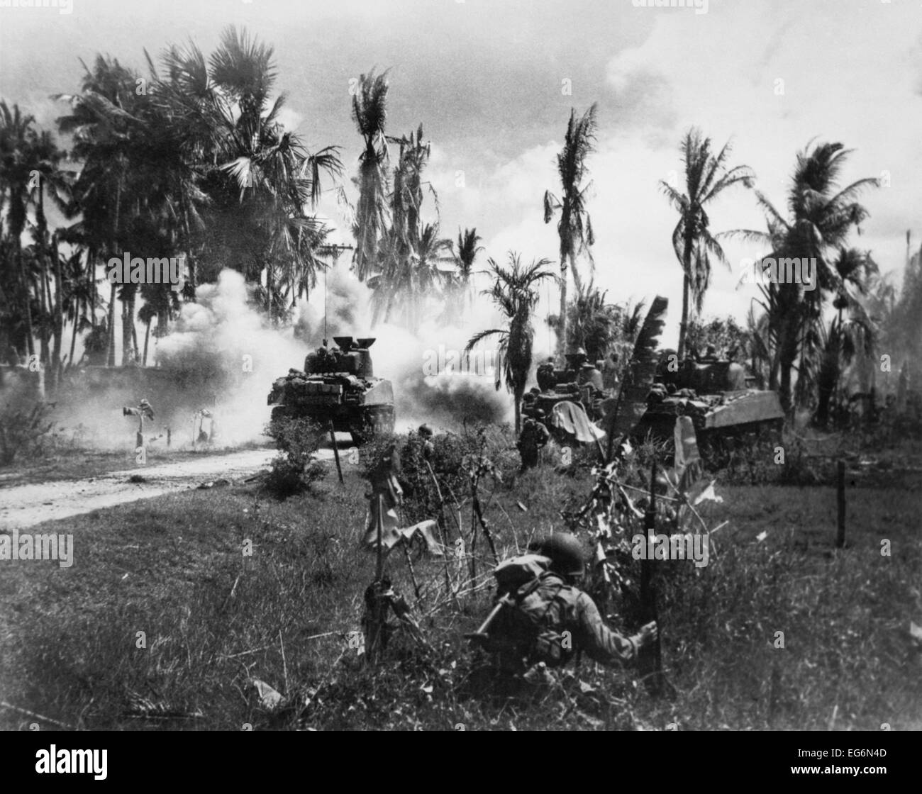 US-Truppen nehmen hinter Panzer während der Bewegung sich auf japanische Stellungen voran. 18. März 1945. Stiefmütterchen-Insel, Philippinen, Stockfoto