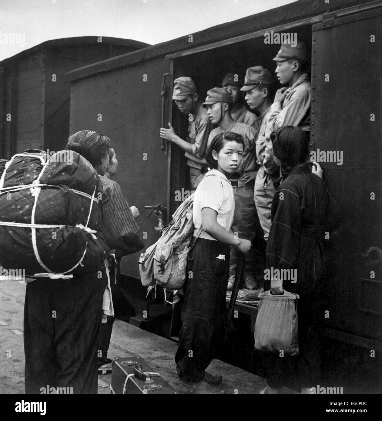 Japanische demobilisierten Soldaten Menge Züge an Hiroshima auf Weg nach Hause. Zivile Frauen warten, um eine bereits überfüllten Güterwagen an Bord Stockfoto