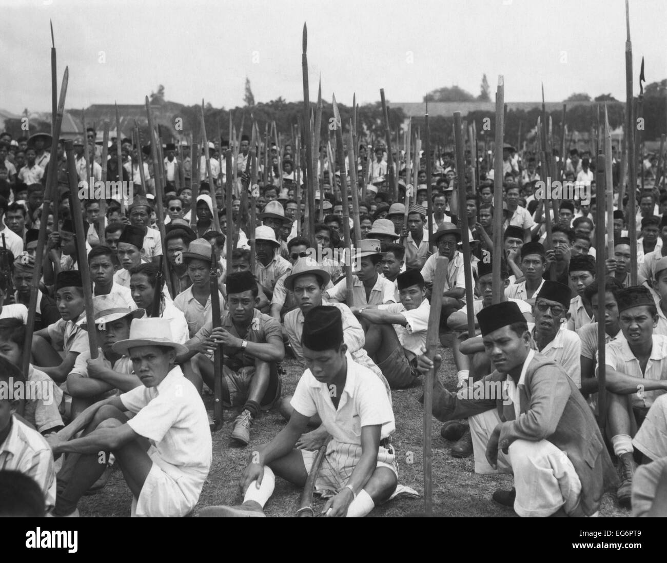 Junge indonesische Männer sitzen am Boden halten geschärft Bambus Stangen. Nach der 17. August 1945, Ausrufung des indonesischen Stockfoto