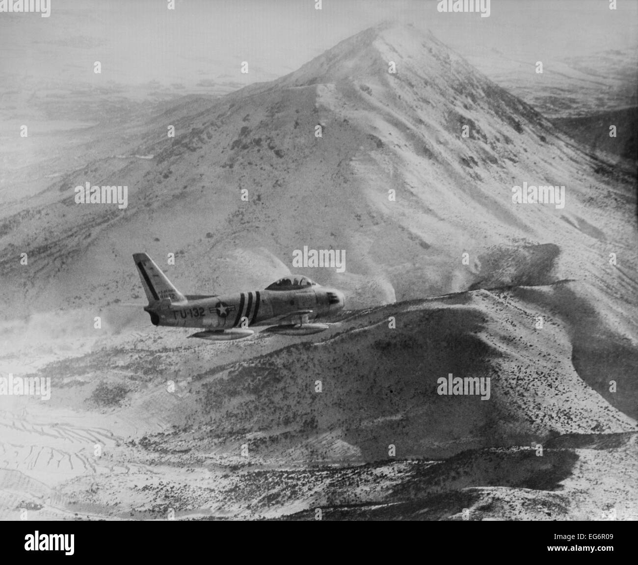 F-86 Sabre Jet gegen eine robuste, Schnee bedeckte Berggipfel in Nordkorea. Es war die am weitesten fortgeschrittene US-Jet in der koreanischen Stockfoto