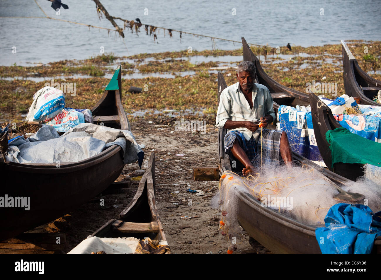 Ein Mann heilt seine Angeln Net, Cochin, Indien Stockfoto