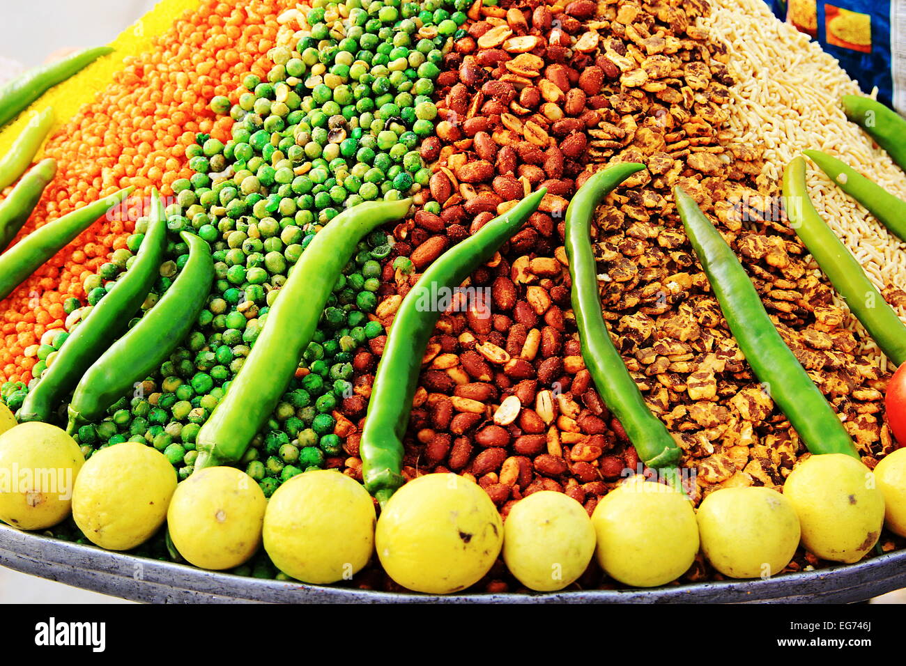 Tablett mit Orange, grün, rot, gelb, weiß Chats mit gewürzt, Erdnüsse, Erbsen, Bohnen, etc. dekoriert mit grünem Chili eine Stockfoto