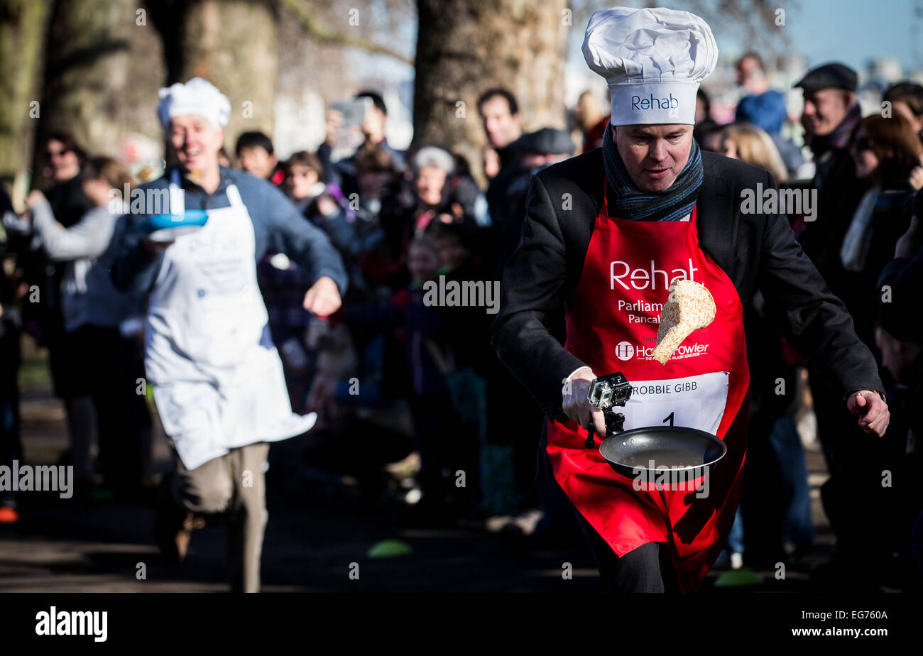 Dienstag, 17. Februar 2015 Robbie Gibb als Journalist für die BBC läuft als Mitglieder des Parlaments und Medienvertreter ein Pfannkuchen-Rennen für einen guten Zweck Reha am Faschingsdienstag in London teilnehmen. Stockfoto