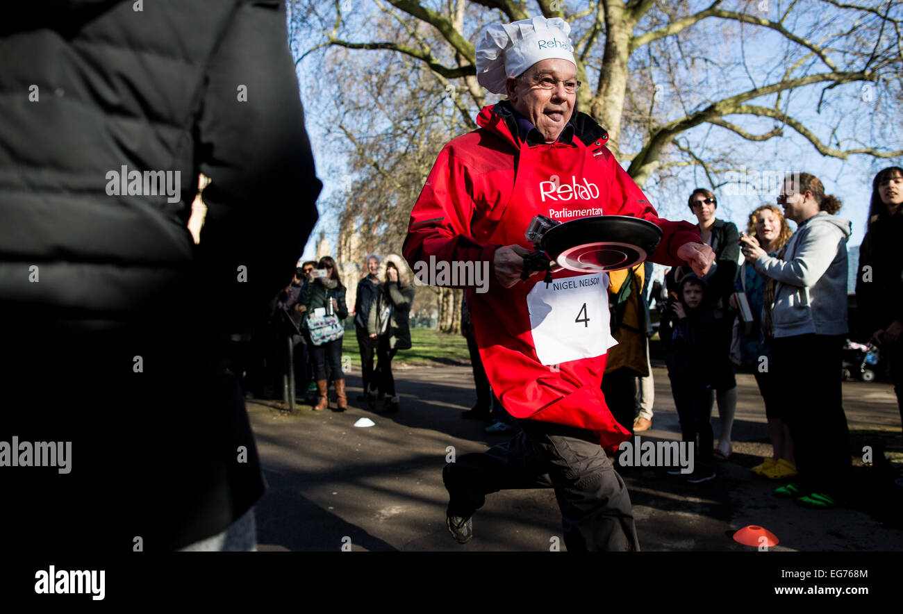 Dienstag, 17. Februar 2015 Nigel Nelson als Journalist für die Zeitung Sunday People läuft als Mitglieder des Parlaments und Medienvertreter ein Pfannkuchen-Rennen für einen guten Zweck Reha am Faschingsdienstag in London teilnehmen. Stockfoto