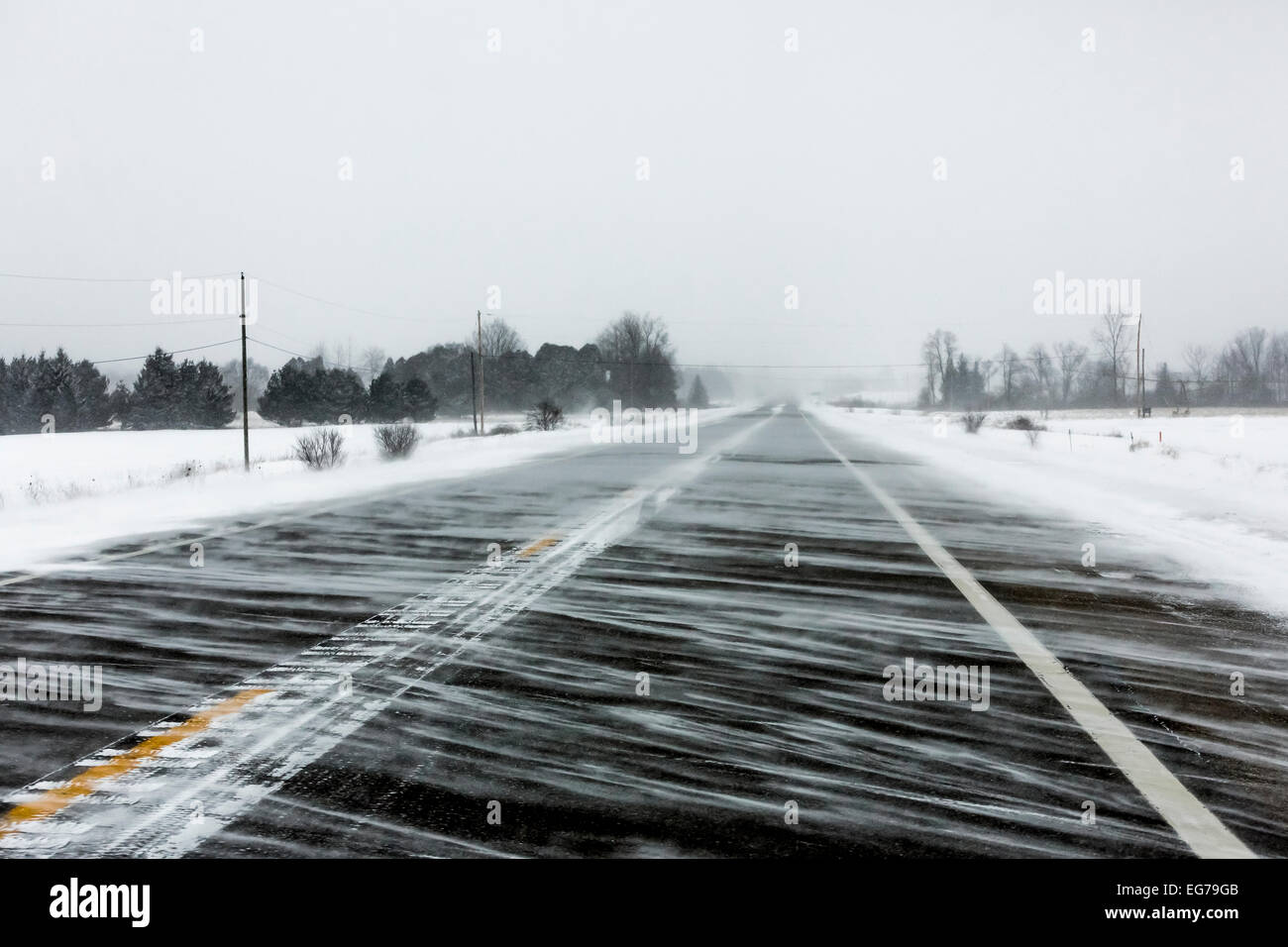 Ranken von Schneeverwehungen an einem kalten und windigen Tag entlang m-20 zwischen Remus und Mt. Pleasant in central Michigan, USA Stockfoto