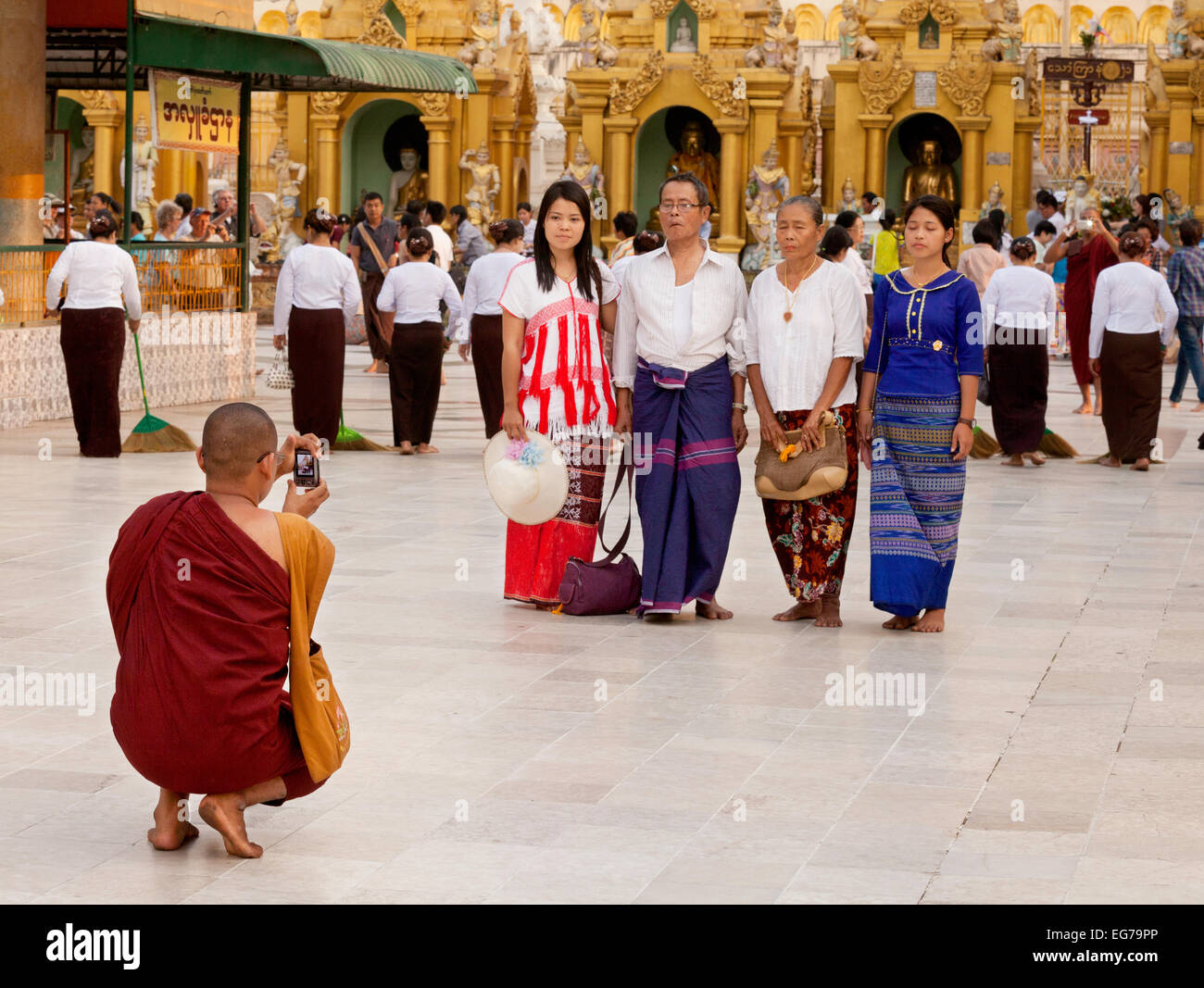 Ein buddhistischer Mönch, wobei ein Familienfoto auf seinem Handy in der Shwedagon-Pagode in Yangon, Myanmar, Asien Stockfoto