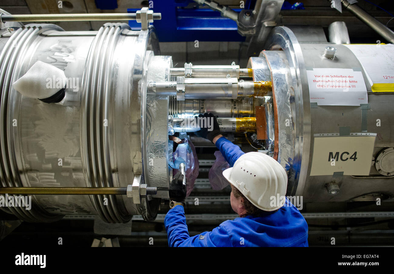 Hamburg, Deutschland. 18. Februar 2015. ILLUSTRATION - steuert ein Mitarbeiter eine Kupplung in den Beschleunigertunnel Partikel des X-Ray-Laser-Projektes European XFEL vorbei das Gaspedal (gelb) in Hamburg, Deutschland, 18. Februar 2015. Das Projekt umfasst ein 3, 4 Kilometer langen Tunnelsystem, in dem nach Fertigstellung Ende 2016, extrem kurzen und intensiven Röntgenblitze generiert werden sollen. Foto: DANIEL BOCKWOLDT/Dpa/Alamy Live News Stockfoto