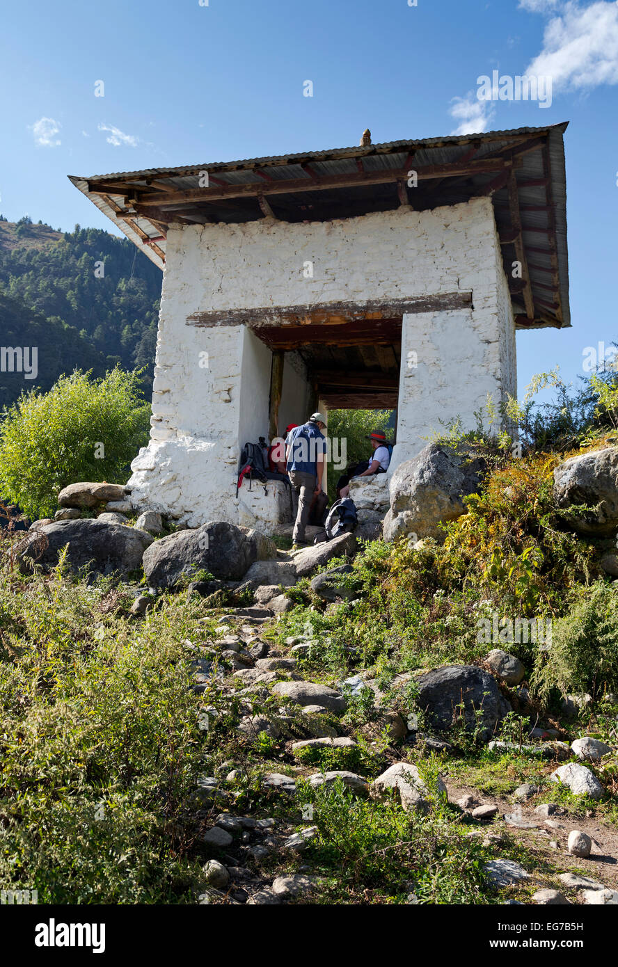 BHUTAN - Wanderer auf den Jhomolhari 2 Trek eine Pause in einem Torbogen errichtet um zu Ehren der göttlichen verrückte im Paro Chhu Tal. Stockfoto