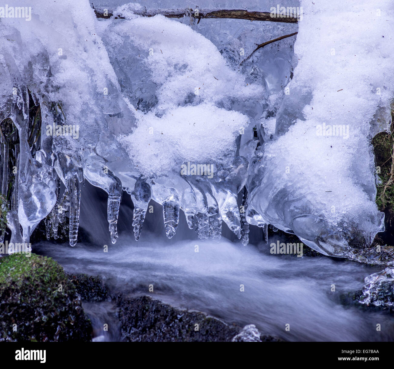 Eiszapfen und Schnee im fließenden Wasser Stockfoto