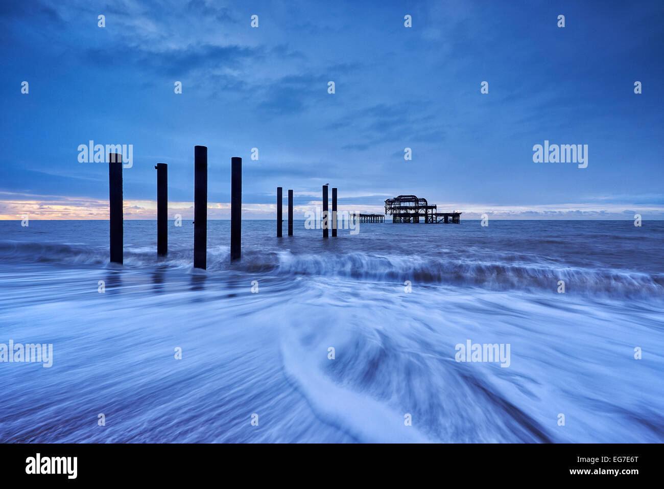 Die zerfallenden Überreste von Brightons West Pier bei Sonnenaufgang mit den Gezeiten hereinkommen. Stockfoto