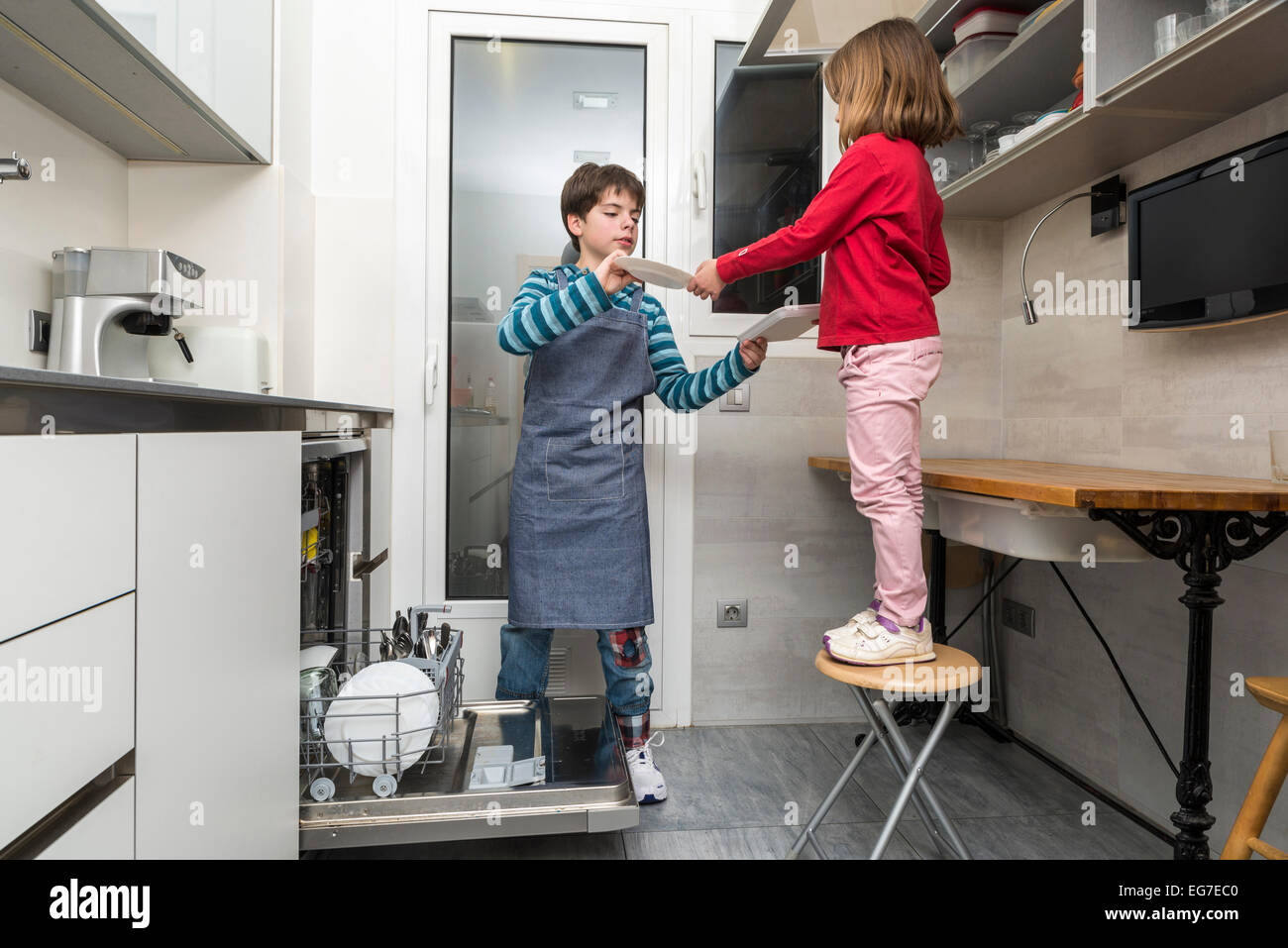 Brüder Entleerung der Spülmaschine zusammen Stockfoto