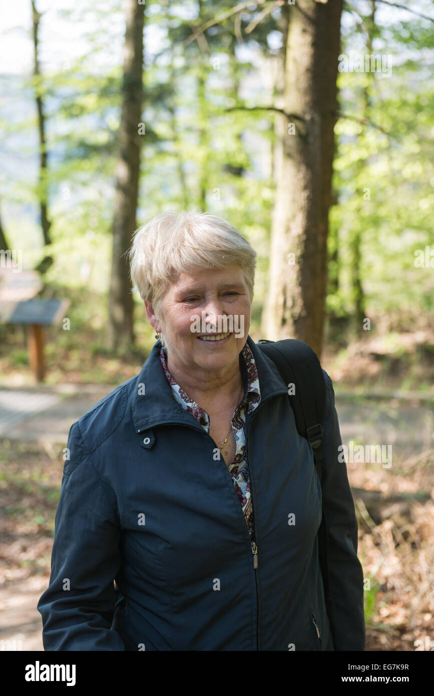 Ältere Frau zu Fuß in den Wald Stockfoto