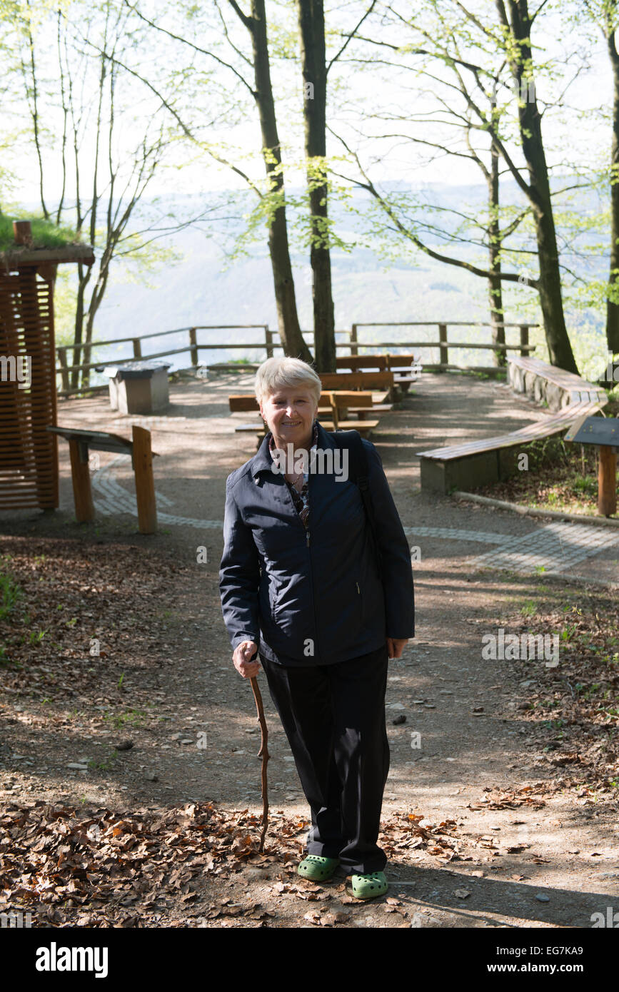 Ältere Frau zu Fuß in den Wald Stockfoto