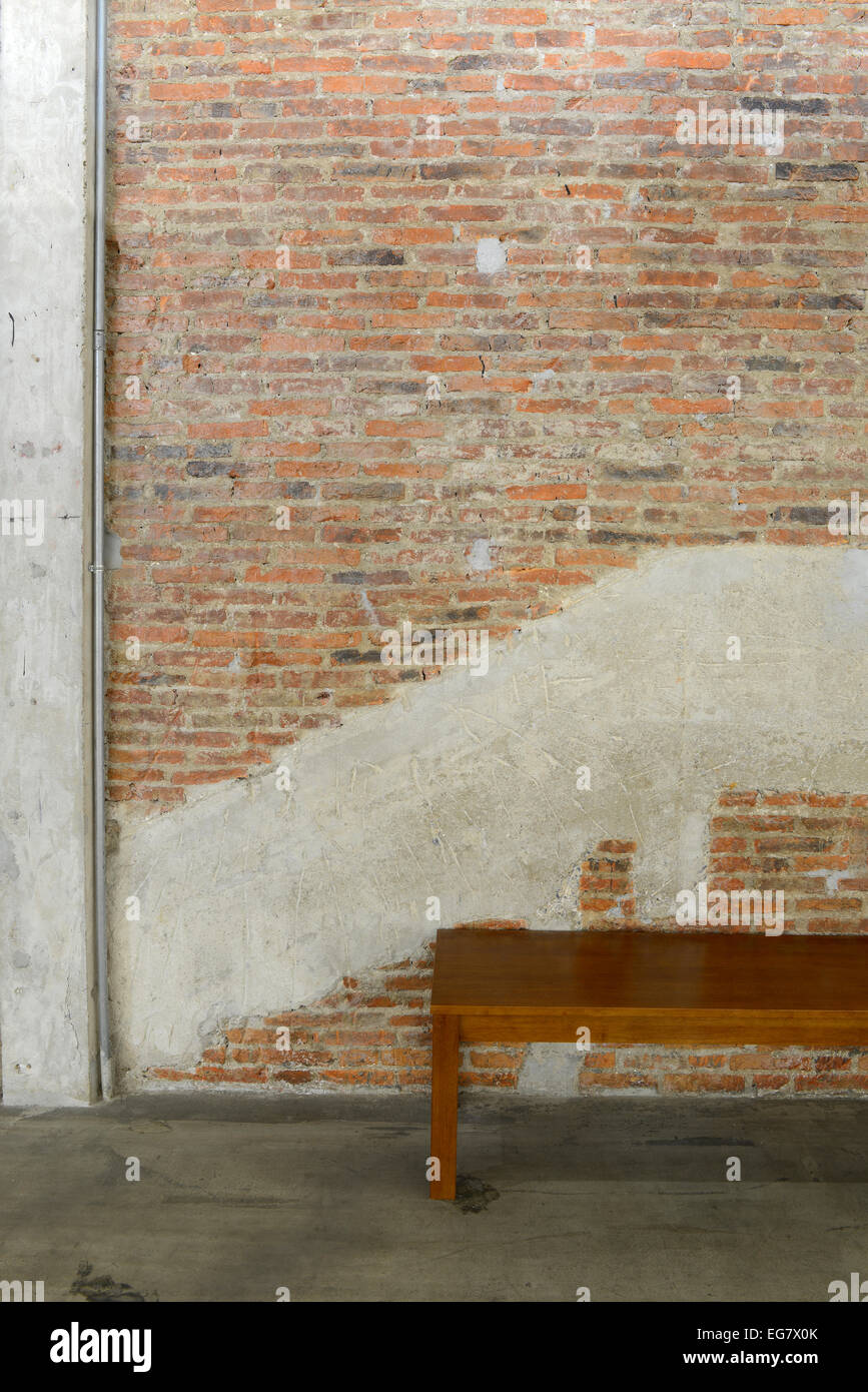 Alte Mauer und konkrete Textur, Hintergrund, dekorieren und langjähriger Holzstuhl Stockfoto