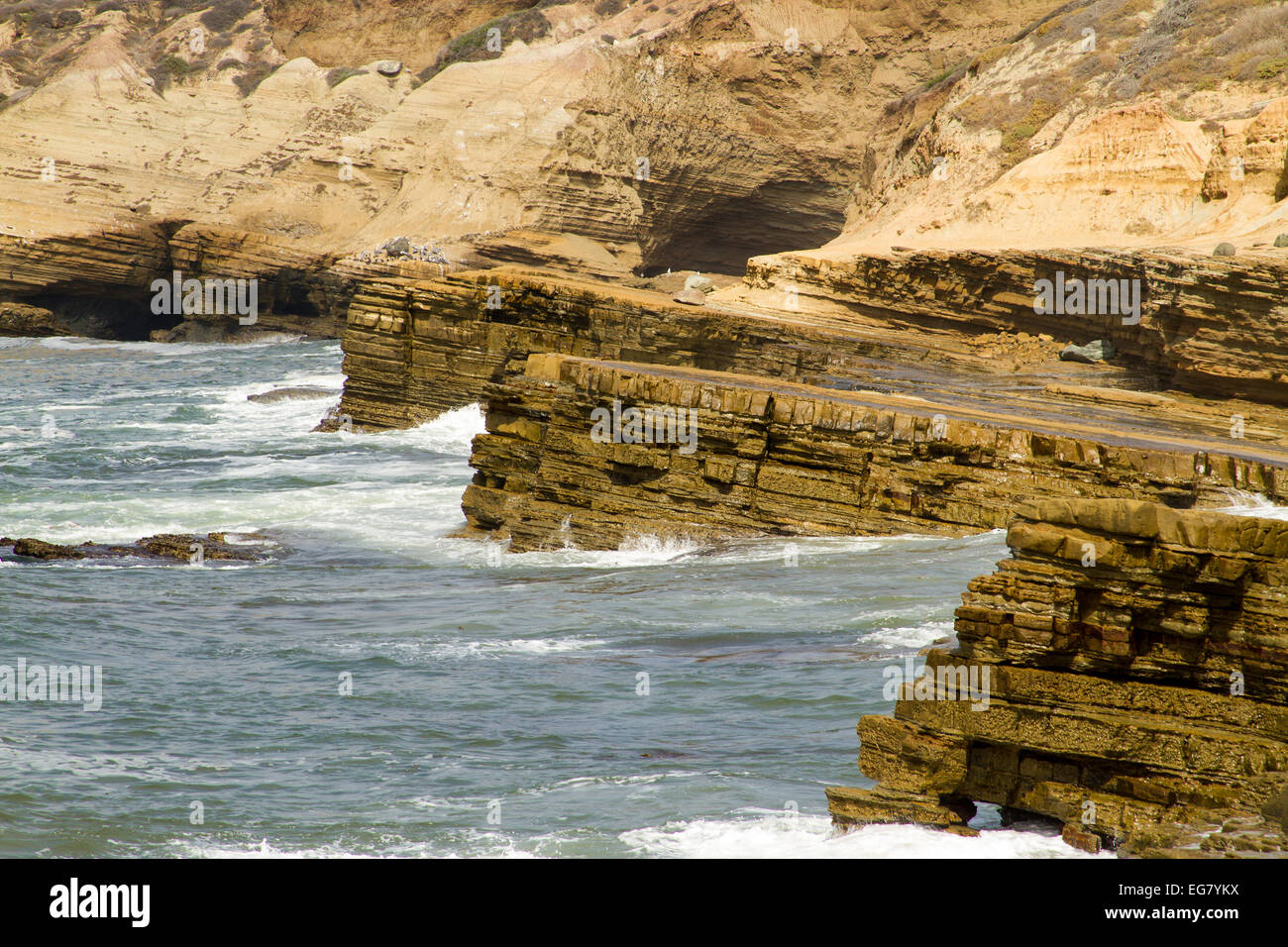 Wellen brechen sich am jetten Küstenfelsen Stockfoto