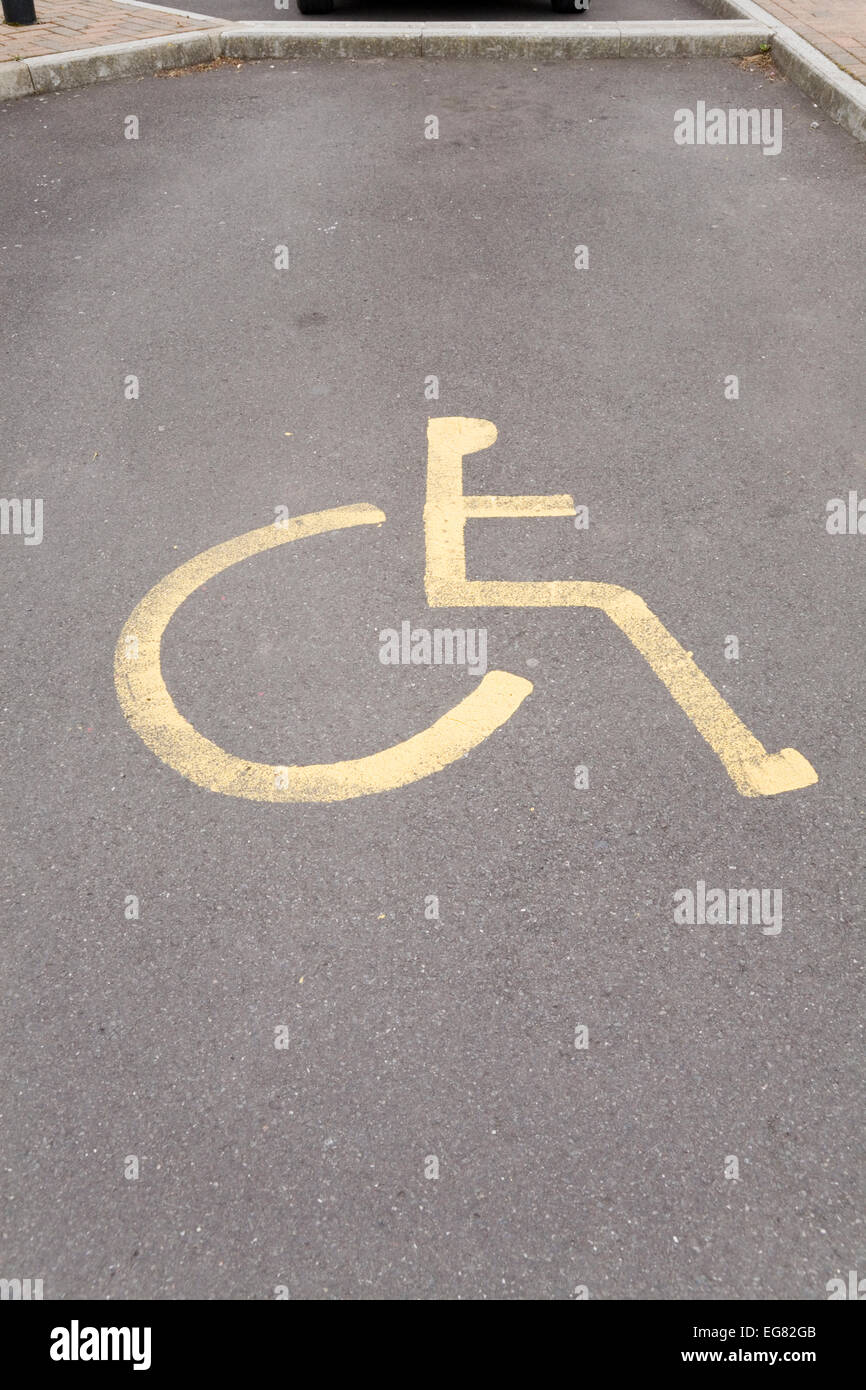 Gemalte Zeichen auf Parkplatz, Parkplatz für Behinderte. Gelbe Rollstuhl Symbol. Stockfoto