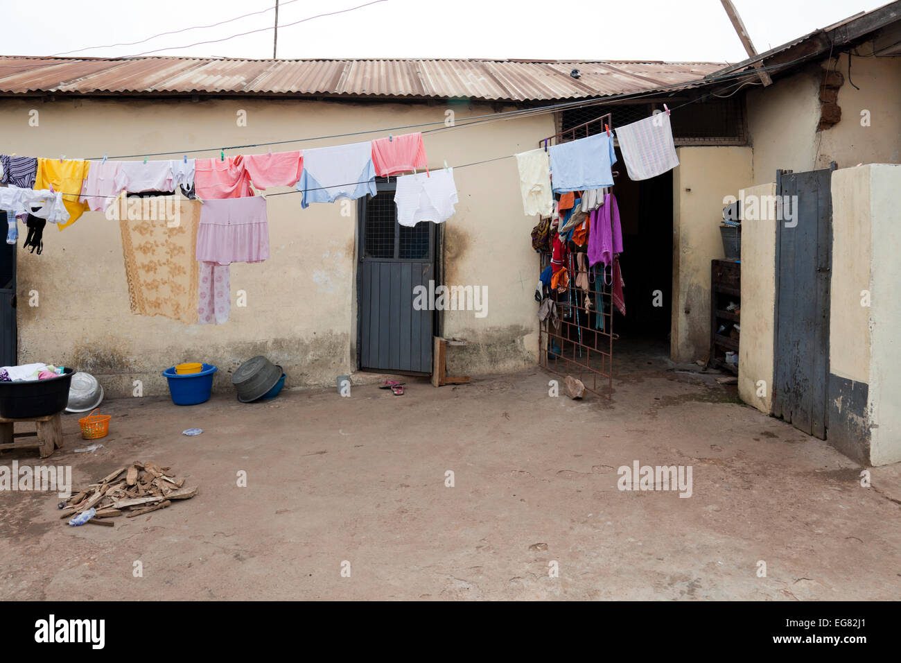 Accra, Hauptstadt von Ghana. Wäscheservice Tag in einem Haus in einer der städtischen Kleinstädte. Der Hinterhof des Hauses hat eine Toilette im Freien und eine Wäscheleine Stockfoto