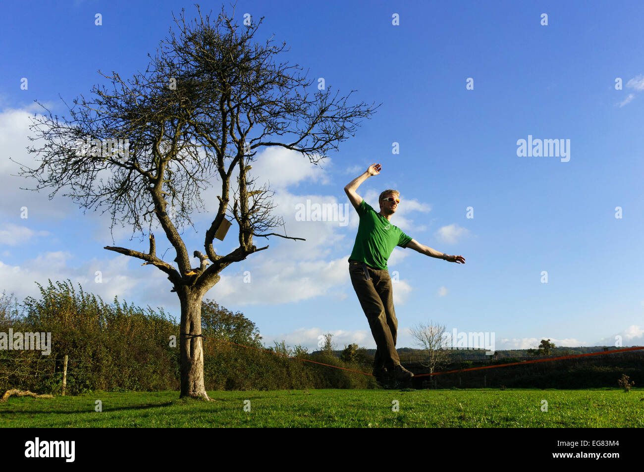 Mann zu Fuß und balancieren auf einer Slackline. England-UK Stockfoto