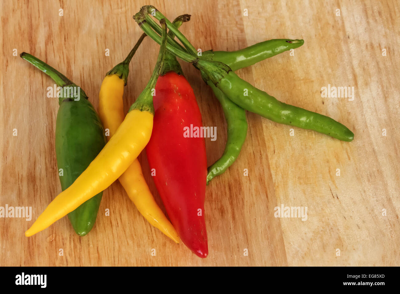 Bunte Chili - rot, grün, gelb - Holz-Hintergrund Stockfoto