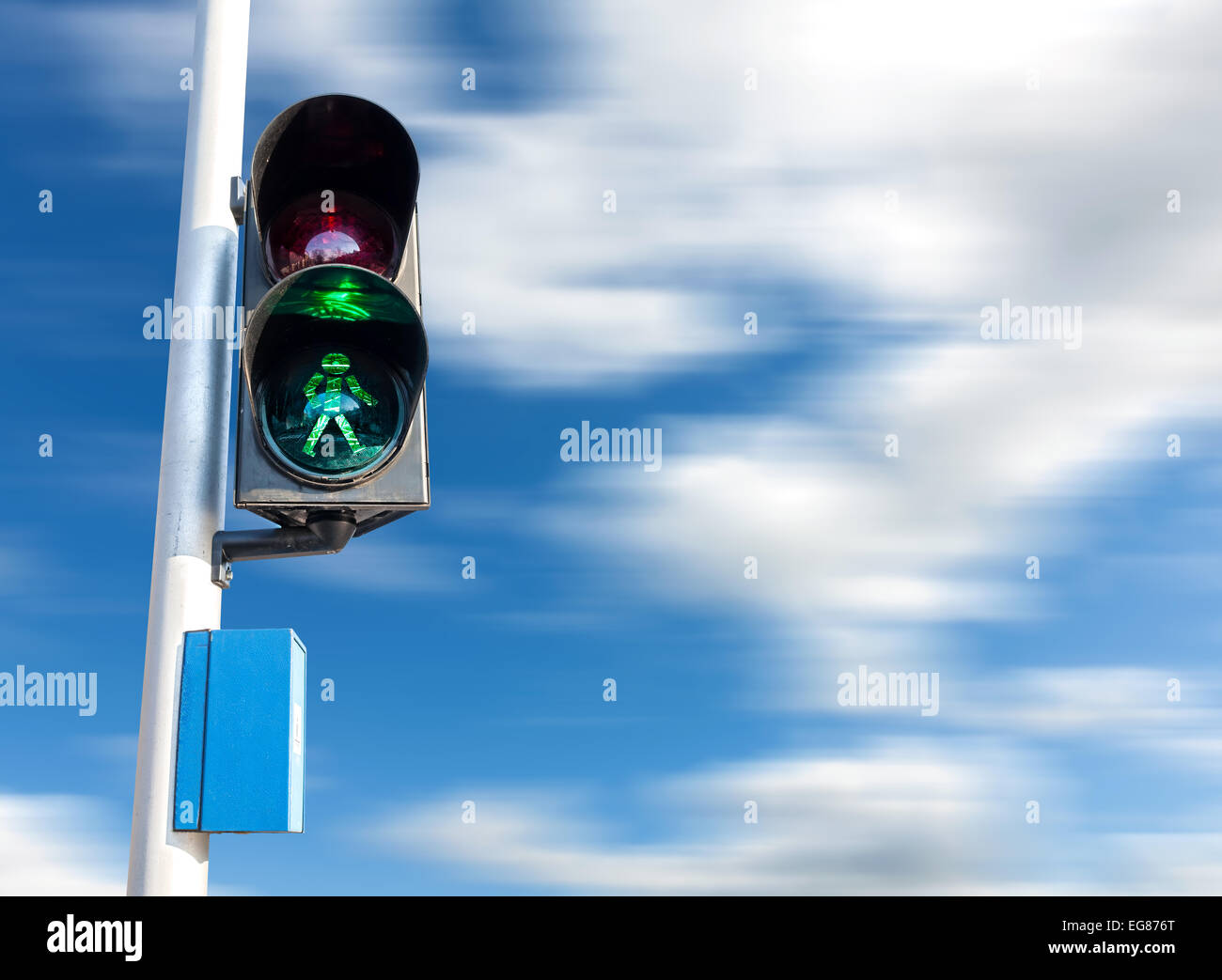Grüne Farbe auf die Ampel für Fußgänger, Bewegung verwischt Himmel. Stockfoto