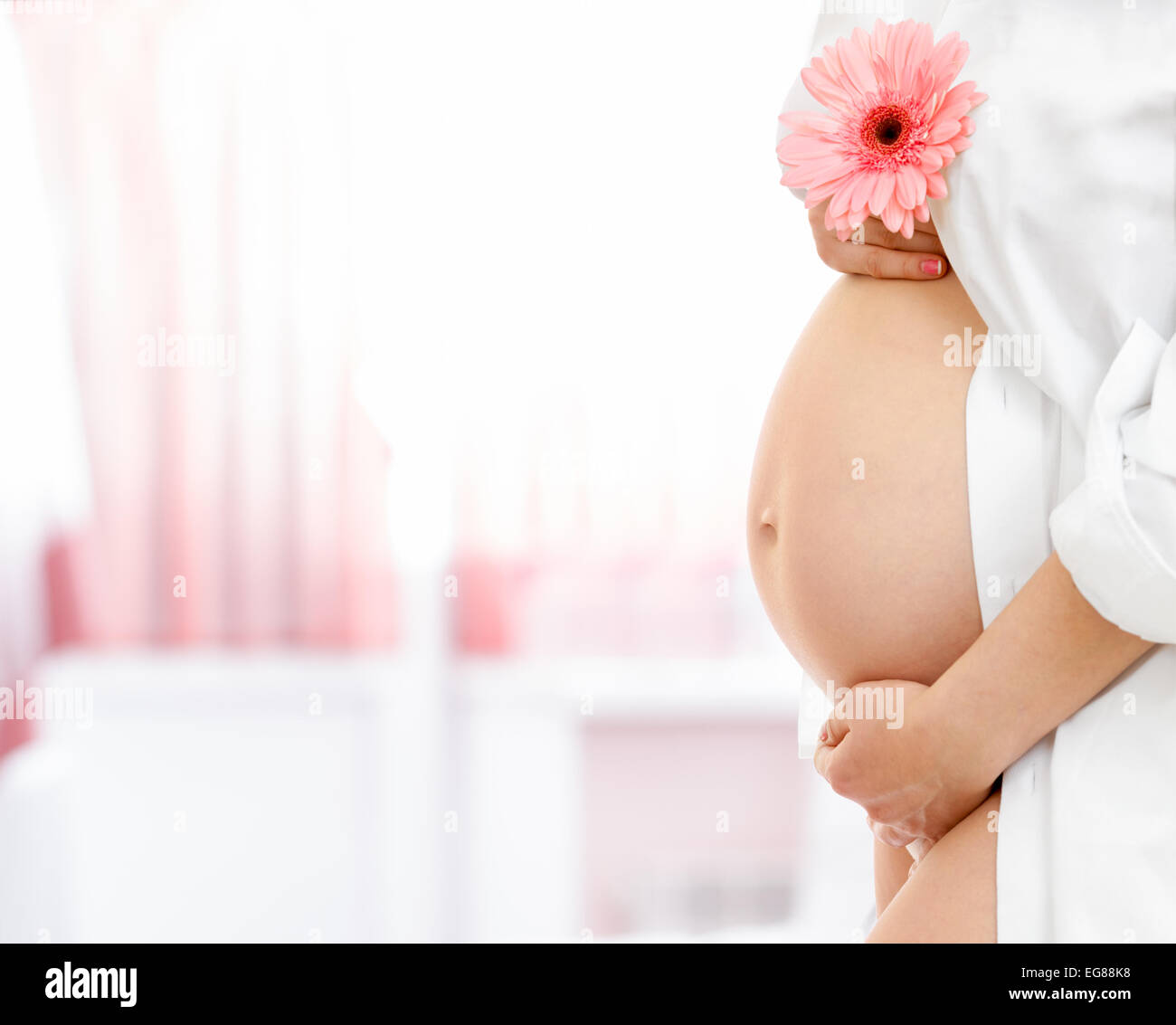 schwangeren Bauch auf unscharfen Krankenhaus Raumhintergrund Stockfoto