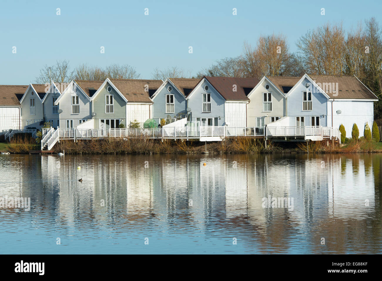 Filmklappe Stil Häuser entlang eines Sees im Wasserzeichen Club, Cotswold Water Park, Gloucestershire, England Stockfoto Filmklappe Stil Häuser entlang eines Sees im Wasserzeichen Club, Cotswold Water Park, Gloucestershire, England Stockfoto