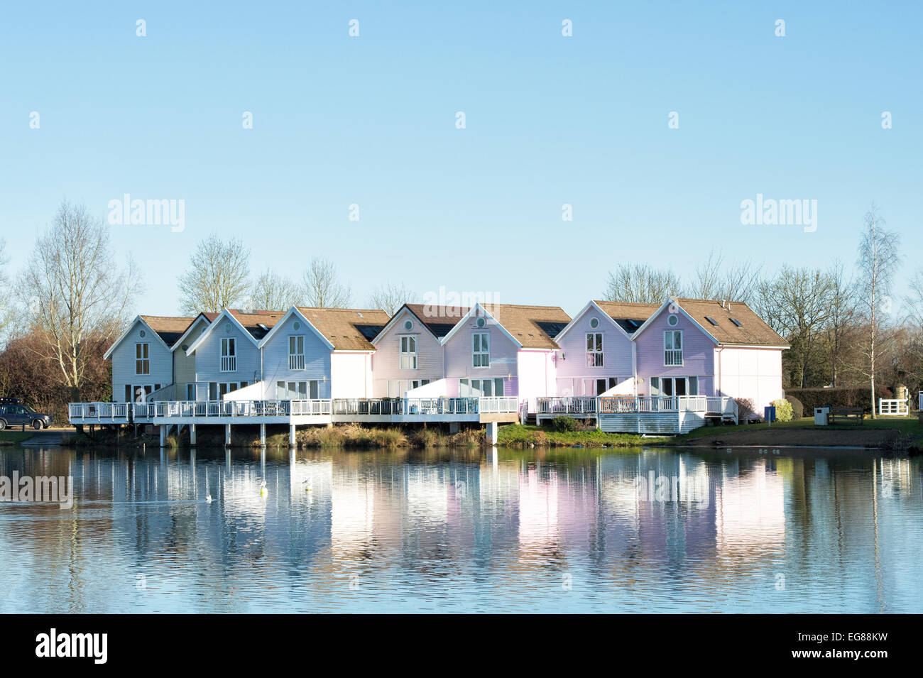 Filmklappe Stil Häuser entlang eines Sees im Wasserzeichen Club, Cotswold Water Park, Gloucestershire, England Stockfoto Filmklappe Stil Häuser entlang eines Sees im Wasserzeichen Club, Cotswold Water Park, Gloucestershire, England Stockfoto