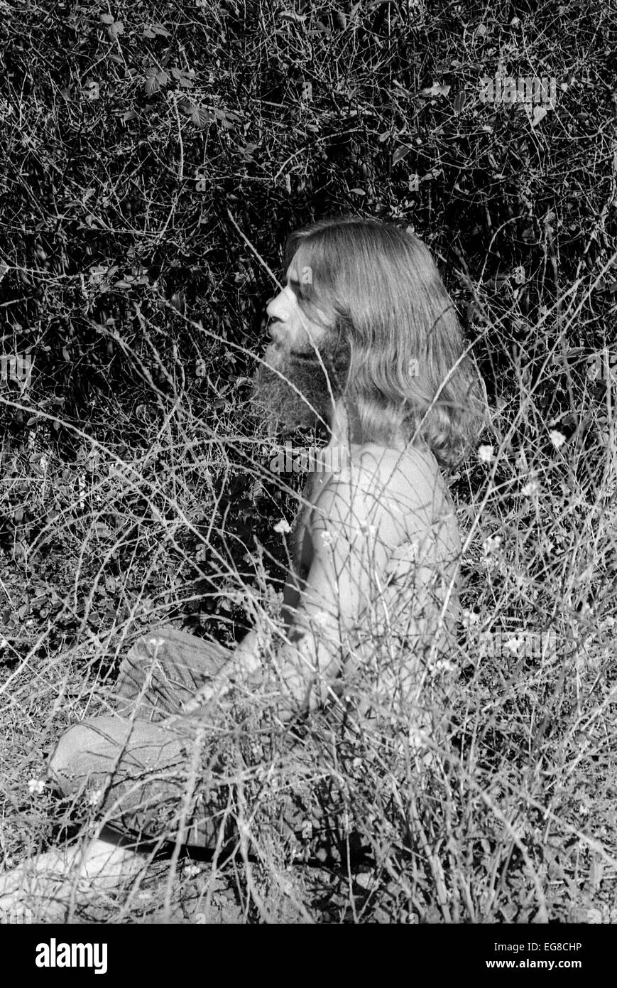 Porträt der 1970er Jahre haariger Hippie Mann Hippie Mann mit Bart und langen Haaren in einem Zustand der spirituellen Vermittlung sitzen im Freien in Pinsel in Berkeley, Kalifornien USA 1971 KATHY DEWITT Stockfoto