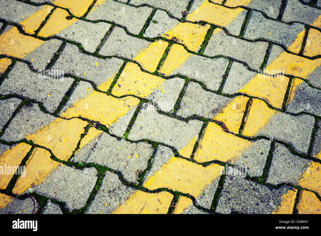 Abstrakte urban Hintergrundtextur. Gelbe Linien-Muster über graue Kopfsteinpflaster Straße. Vintage Foto-filter Stockfoto