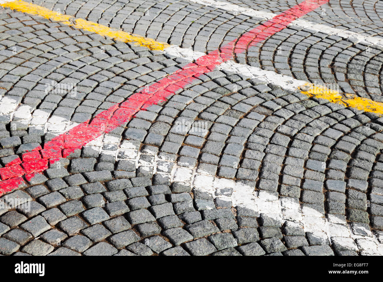 Weiße, rote und gelbe Straße Markierungslinien über auf graue Kopfsteinpflaster, abstrakte städtischen Hintergrund Stockfoto