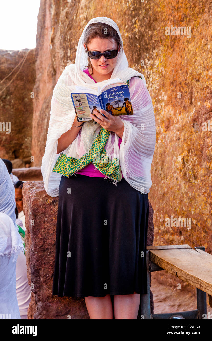 Ein Tourist Lesen der Lonely Planet-Reiseführer nach Äthiopien, Bete Maryam Kirche, Lalibela, Äthiopien Stockfoto
