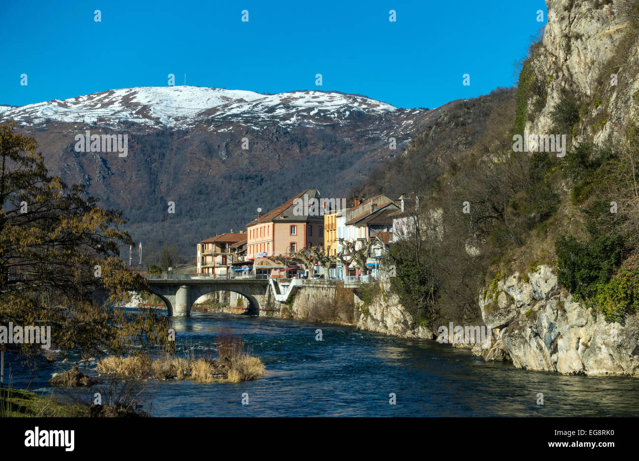 Tarascon Sur Ariège und Ariege Fluss mit Brücke und Gebäude mit schneebedeckten Bergen Stockfoto